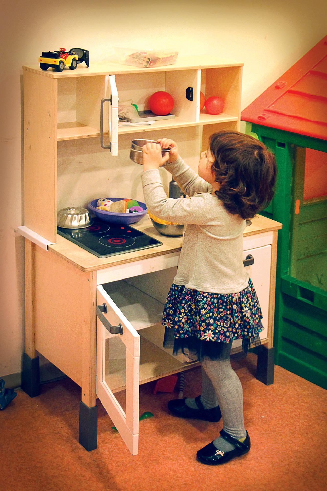 A girl playing in a toy kitchen