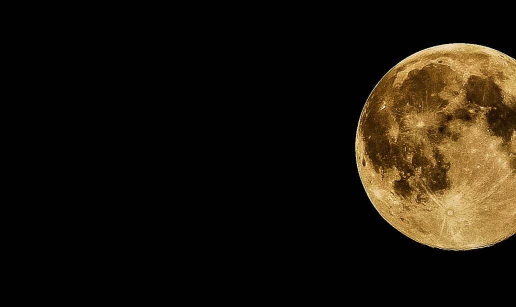 a golden full moon on the right side of a wide, black sky.
